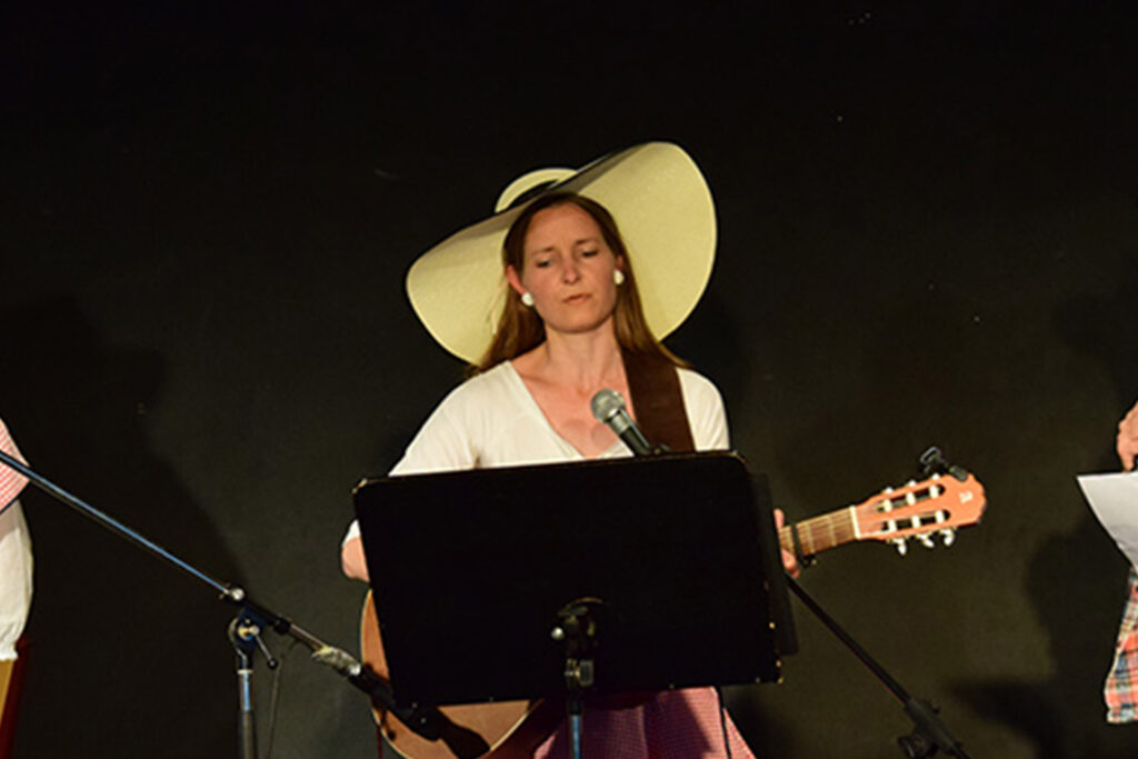 Abend der Poesie Montessori Schule Peißenberg: Eine Schülerin spielt Gitarre und singt.